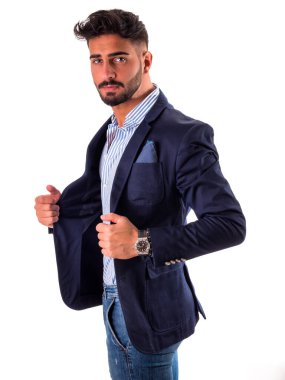 Takım elbiseli, şık gömlekli, beyaz tenli ve kameraya bakan yakışıklı, zarif bir genç.