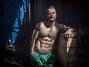 Spor salonunda egzersiz sırasında ayakta, kameraya bakarak kas yakışıklı genç