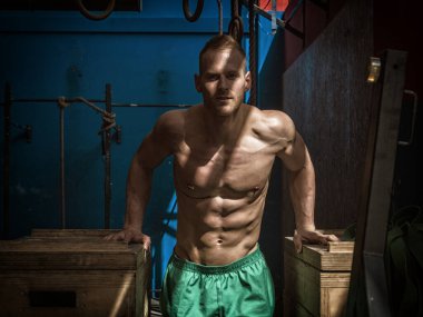 Spor salonunda egzersiz sırasında ayakta, kameraya bakarak kas yakışıklı genç