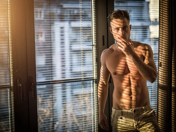 Portret Seksowny Sprawny Człowiek Pokryty Cień Paski Okna Patrząc Kamery — Zdjęcie stockowe