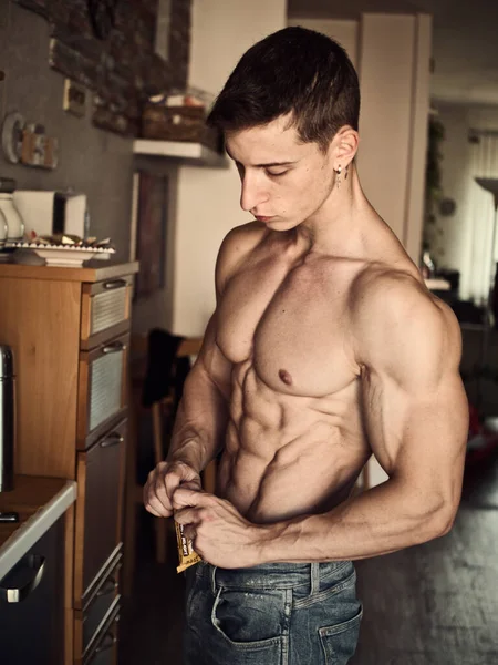 Shirtless Muscular Jovem Comendo Cereal Barra Proteína Cozinha — Fotografia de Stock