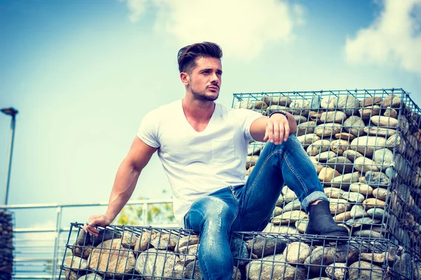 Shot Handsome Man Sitting Rack Full Pebbles Looking Confidently Away — Stock Photo, Image