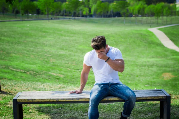街の公園で落ち込んで悲しい筋肉質の男素敵な夏の日にベンチに座って泣きながら — ストック写真