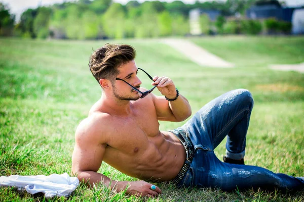 光着膀子的合适的男性的模型的令人放松的躺在草地上 从上面拍摄 — 图库照片