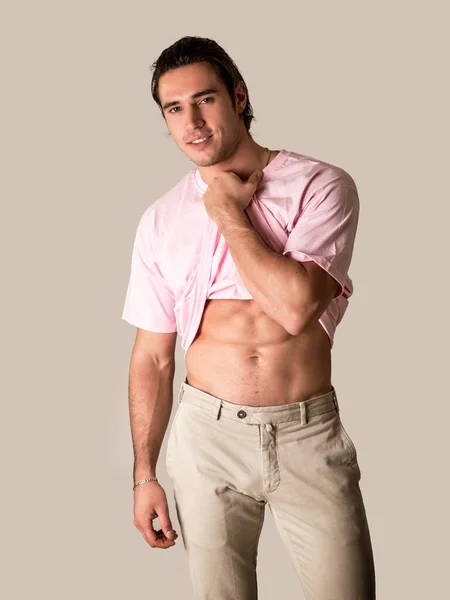 Hombre Joven Guapo Musculoso Fondo Gris Mirando Cámara Tirando Camiseta — Foto de Stock