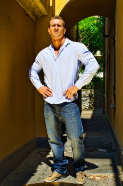 İtalya 'nın ara sokaklarında yakışıklı genç bir atletik. Yazın gömlek ve kot pantolon giyiyor.