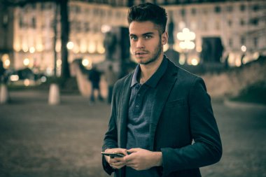 Torino, İtalya 'da gece vakti arkasında şehir ışıkları olan çekici genç adam portresi.