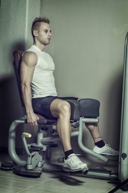 fit ve çekici genç adam bacaklarını çalışma ve ekipmanları egzersiz jimnastik salonu