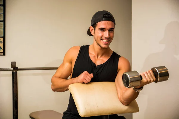 Bonito Jovem Musculoso Exercitando Bíceps Ginásio Com Halteres Sorrindo Olhando — Fotografia de Stock
