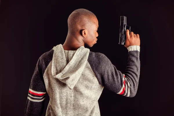 Fiatal Jóképű Fekete Férfi Kezében Egy Kézifegyverrel Sötét Háttérrel Stúdióban — Stock Fotó