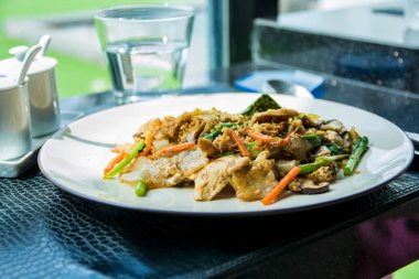 Beyaz tabakta servis edilen tavuklu taze Tayland yemeği yakın plan..