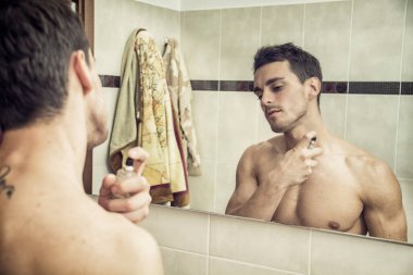 yakışıklı bir genç adam olarak onun ev banyo parfüm veya kolonya boynunda püskürtme