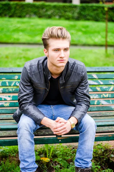 Przystojny Młody Blondyn Siedząc Ławce Parku Zielona Drewniane — Zdjęcie stockowe