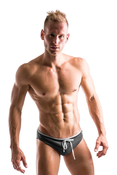 白い背景に隔離された彼の筋肉体格を示す自信を持つ男性の運動ボディービルダー — ストック写真