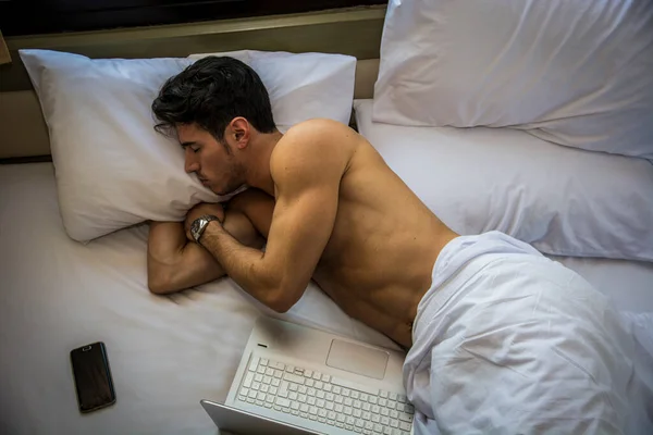 Zbliżenie Młody Człowiek Ciemnymi Włosami Śpi Łóżku Obok Laptopa Komputera — Zdjęcie stockowe