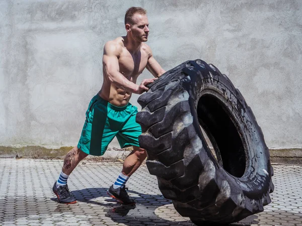 Handsome Muscular Young Man Exercising Flipping Big Truck Tire Outdoor — Stock Photo, Image