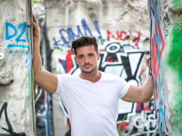 Attraktiver Muskelmann Lehnt Bunter Graffiti Wand Und Trägt Weißes Shirt — Stockfoto