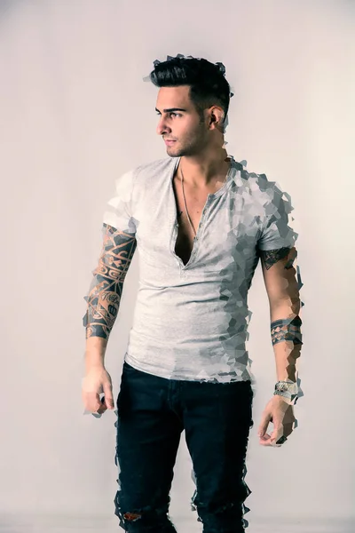 灰色のTシャツを着たハンサムな入れ墨の若い男 デジタル処理されたショットで白の背景に対して隔離された立って — ストック写真
