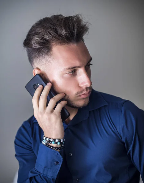 Привлекательный Молодой Человек Использующий Свой Мобильный Телефон Звонка Нейтральном Сером — стоковое фото