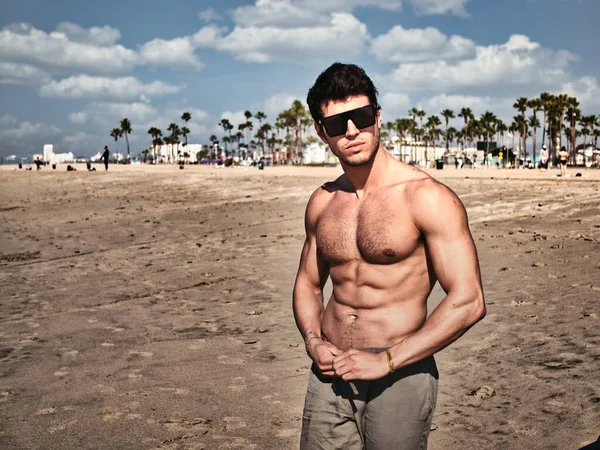 在美国加利福尼亚州威尼斯海滩 一位英俊的年轻人穿着短裤 赤身裸体地站在海滩上 显得肌肉发达 — 图库照片
