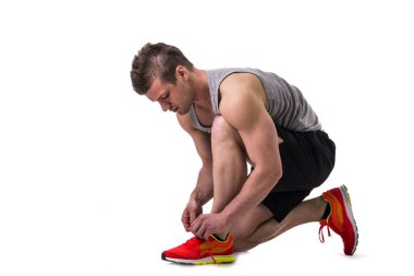 Ayakkabı bağcıklarını bağlayan bir adam çömelirken