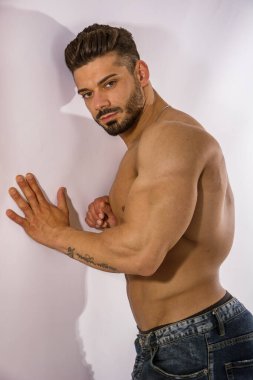 Eli göğsünde üstsüz bir adam.