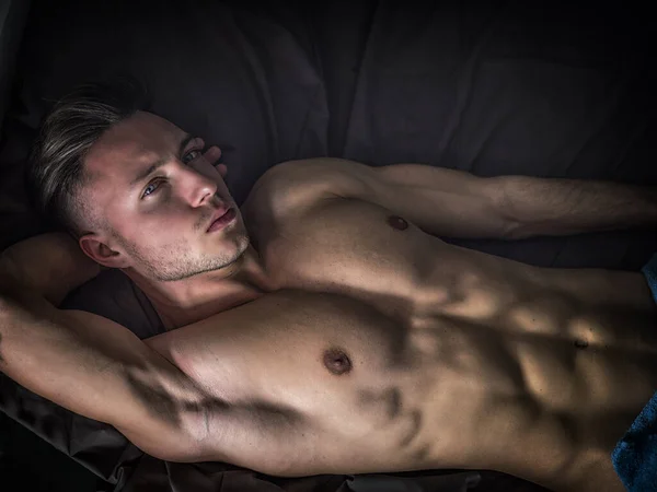 Shirtless Man Laying Black Sheets Couch — Stock Photo, Image