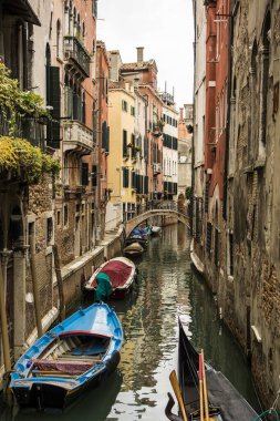 Birkaç tekne dar bir kanal boyunca park edilmiş. İtalya, Venedik 'te dar bir kanal boyunca park etmiş teknelerin fotoğrafları.