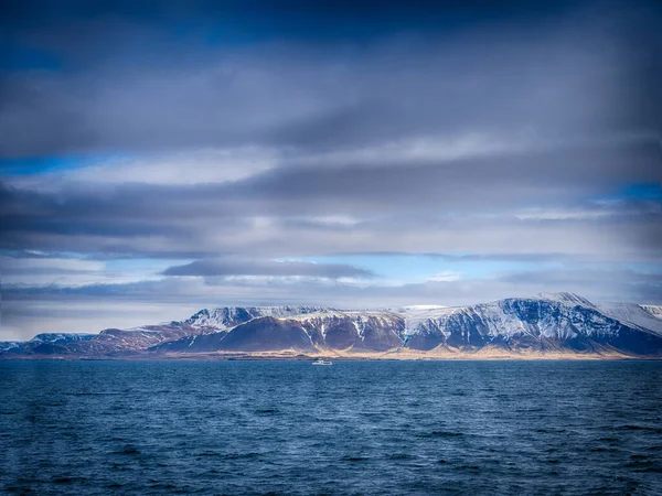 バックグラウンドに山がある大きな水 アイスランドの穏やかな水の体に反映された山々と素晴らしい風景の写真 — ストック写真