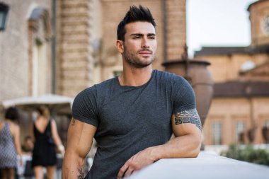 Çekici kaslı adam Avrupa şehir merkezinde poz veriyor, Torino, İtalya, kameraya bakıyor.