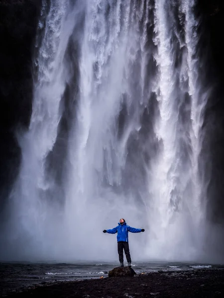 Mężczyzna Turysta Ciepłych Ubraniach Rozciągający Ramiona Stojący Pobliżu Wodospadu Skogafoss — Zdjęcie stockowe