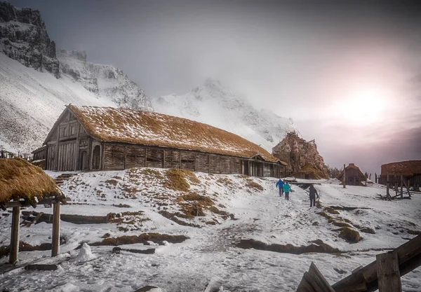 Вид Сзади Людей Идущих Склону Снежного Холма Старому Деревянному Дому — стоковое фото