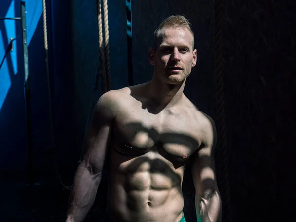 Aantrekkelijke Blondine Mannelijke Bodybuilder Korte Broek Binnen Donkere Sportschool Met — Stockfoto