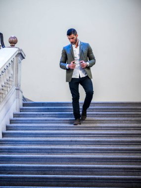 Takım elbiseli bir adam merdivenlerden iniyor.