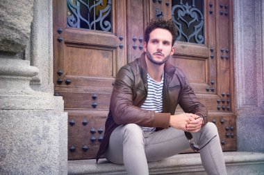 Binanın merdivenlerinde oturan bir adam. Bir binanın merdivenlerinde oturan bir adamın fotoğrafı.