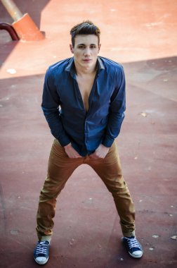 Mavi gömlekli bir adam resim için poz veriyor. Mavi gömlekli bir adamın fotoğrafı. Kameraya bakıyor.