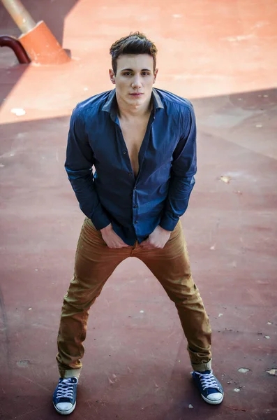 Mavi gömlekli bir adam resim için poz veriyor. Mavi gömlekli bir adamın fotoğrafı. Kameraya bakıyor.