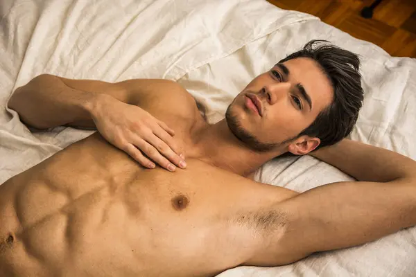 Beyaz Çarşaflarla Yatakta Yatan Üstsüz Bir Adam Üstsüz Bir Adamın — Stok fotoğraf