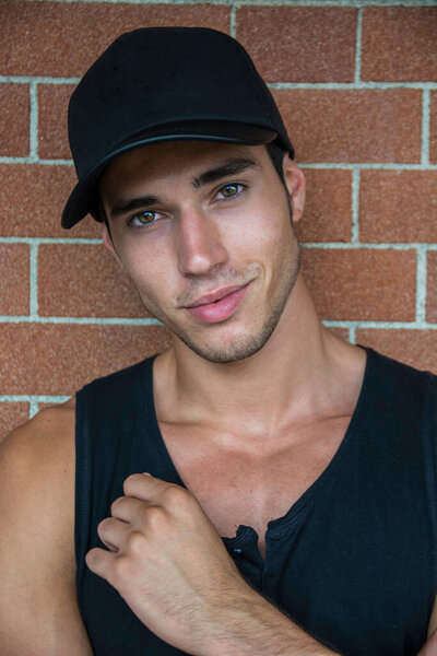 Мужчина в черной рубашке и черной шляпе. Фото стильного и красивого молодого человека в черной рубашке и шляпе, улыбающегося в камеру