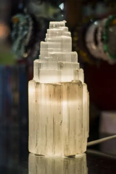 A tall selenite lamp tower sitting on top of a table. Photo of tall selenite lamp tower sitting on top of a table