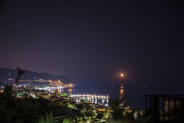 Bir şehrin ve Akdeniz 'in gece görüşü. İtalya 'nın Liguria sahiline kurulmuş büyüleyici bir kasaba olan Diano Marina' nın göz kamaştırıcı gece siluetinin fotoğrafı.