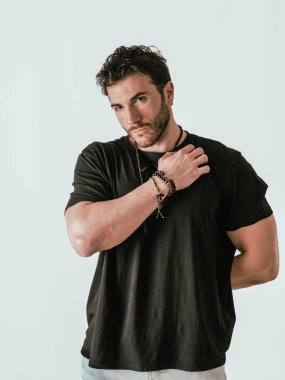 Siyah gömlekli bir adam beyaz arka planda bir resim için poz veriyor.