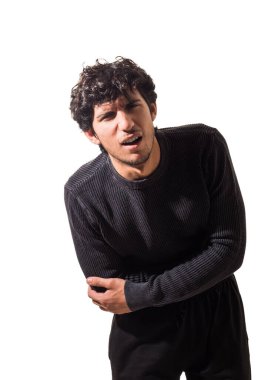 Genç bir adam karın ağrısı, karın ağrısı, siyah kazak ve siyah pantolon giyiyor.