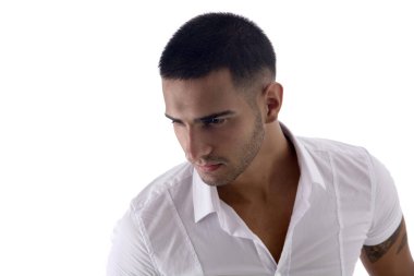 Beyaz gömlekli ve kot pantolonlu yakışıklı genç adam stüdyoda beyaz arka planda yalnız poz veriyor, ciddi.