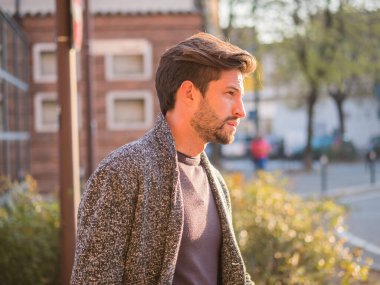 Avrupa 'da şehir merkezinde yakışıklı bir genç adam ayakta duruyor.