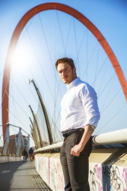 Giyen dışında yakışıklı genç adam beyaz gömlek, kameraya, gün atış arıyorsunuz.