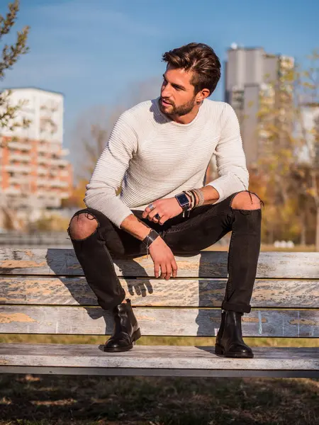 Avrupa 'daki şehir parkında oturan yakışıklı bir adam.