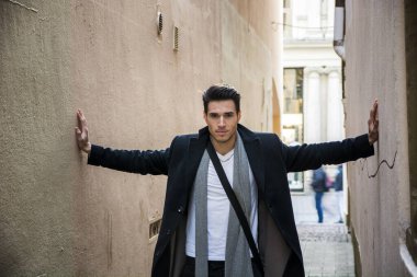 genç adam iki duvar bastırdı. baskı, anksiyete kavramı. Eli ayağı tutmaz terkedilmiş tuğla Endüstriyel Bina dar koridorda duran