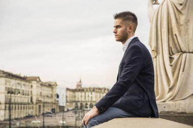 Yakışıklı genç açık giyen ceket ve gömlek Avrupa şehri inşa tarihi beklemede. Torino, İtalya