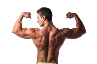 Kendine güvenen bir adam kaslı vücudunu sergiliyor, sadece iç çamaşırı giyerken kol kaslarını esnetiyor. Sahne güç ve güç yayar..